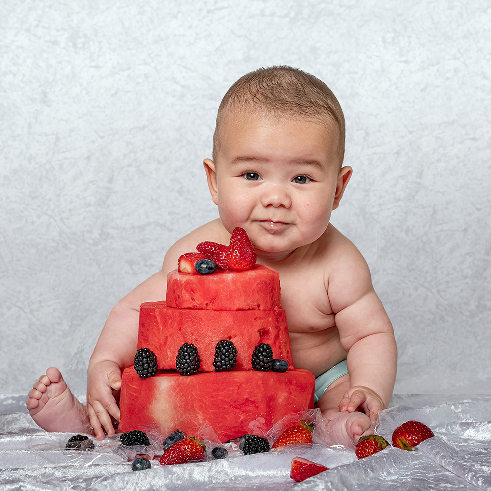 Baby posing with watermelon cake
